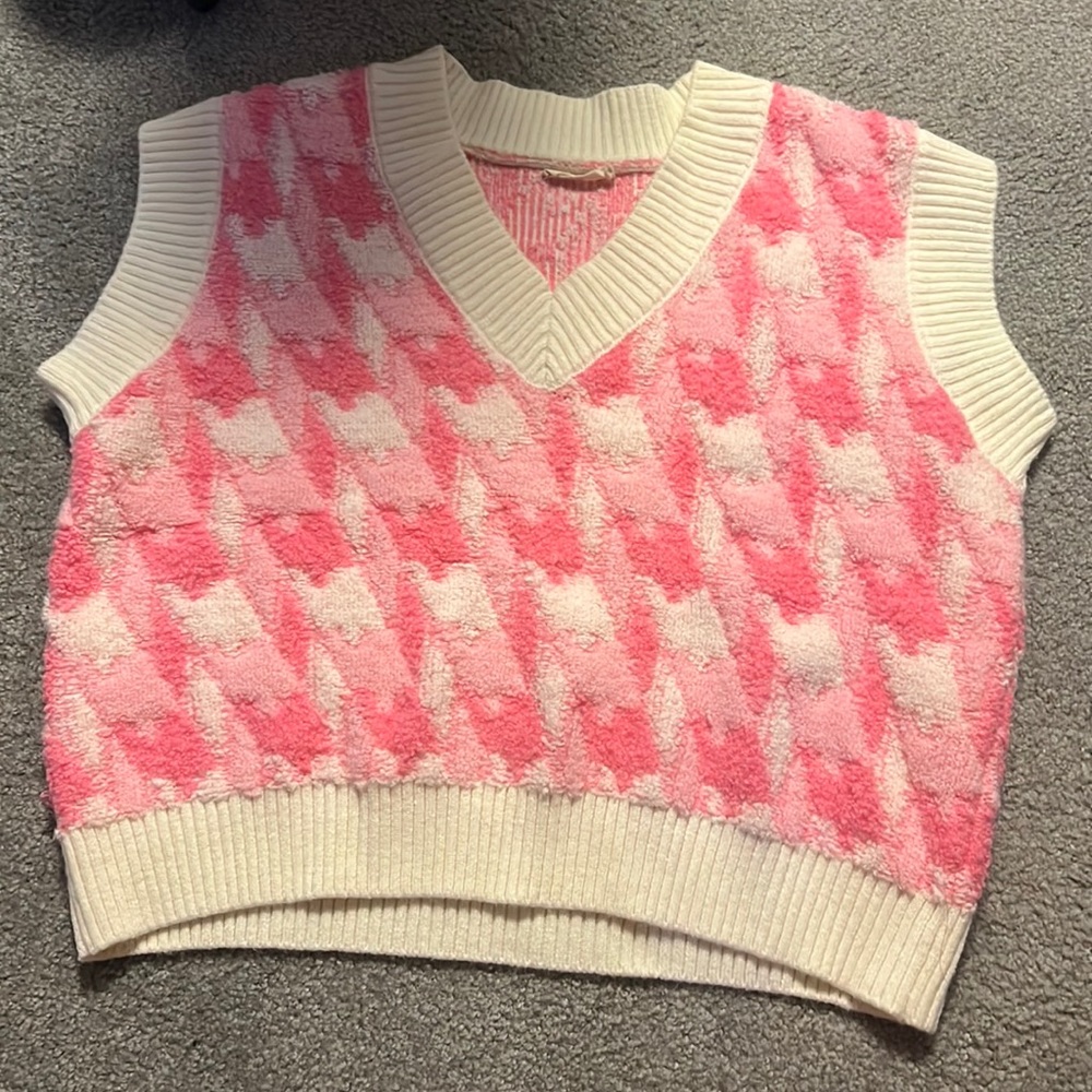 A pink and white sweater vest that is from Pink Ripple